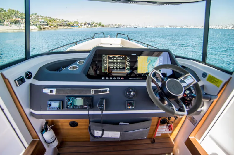  Yacht Photos Pics 2022 Axopar 28 Cabin boat dashboard with navigation screens and steering wheel.