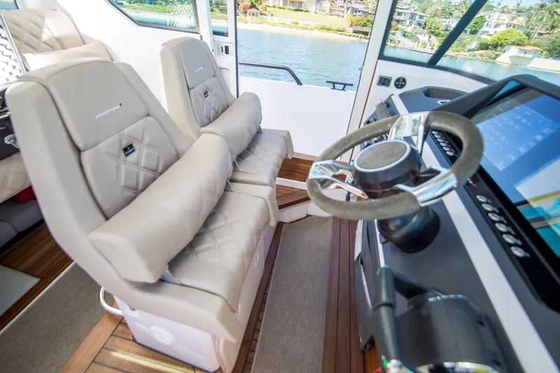  Yacht Photos Pics Interior of 2022 Axopar 28 Cabin boat with modern steering and comfortable seating.
