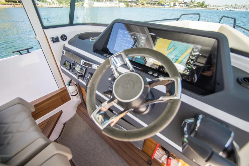  Yacht Photos Pics 2022 Axopar 28 Cabin boat interior with modern steering and navigation system.