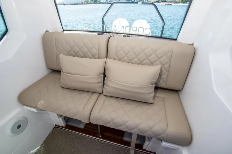  Yacht Photos Pics Luxurious seating in 2022 Axopar 28 Cabin boat with quilted cushions and scenic water view.