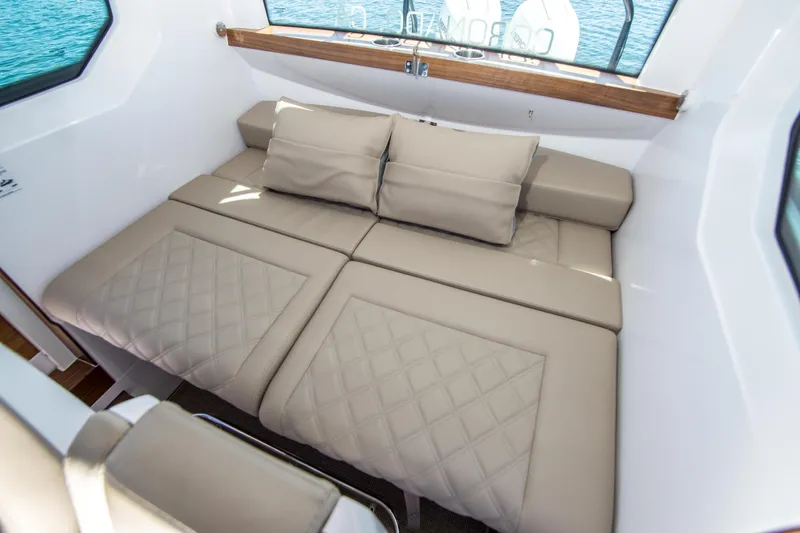  Yacht Photos Pics Luxurious interior of 2022 Axopar 28 Cabin with beige seating and cushions.