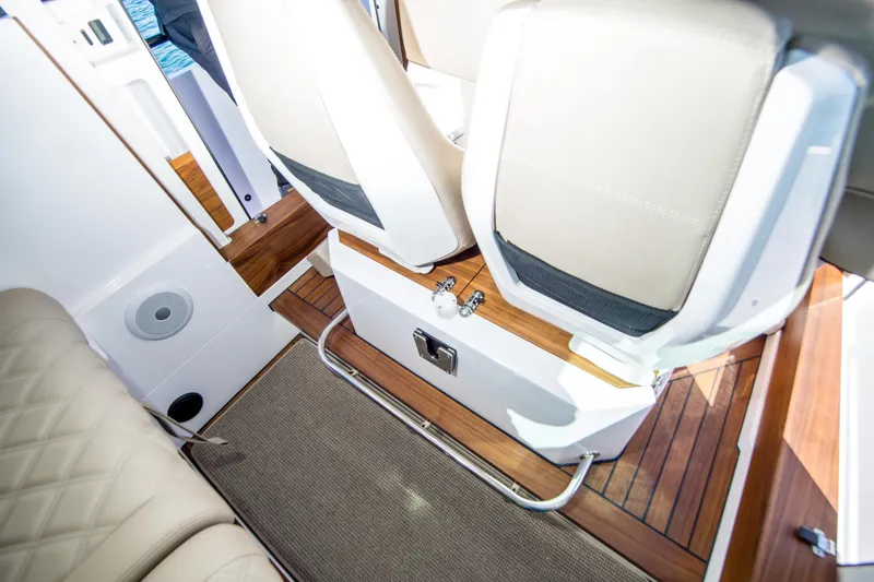  Yacht Photos Pics 2022 Axopar 28 Cabin interior with beige seating and wooden flooring.