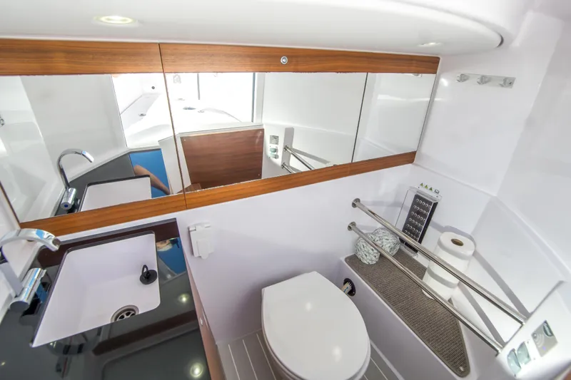  Yacht Photos Pics Modern bathroom interior in 2022 Axopar 28 Cabin boat, featuring sleek design and amenities.