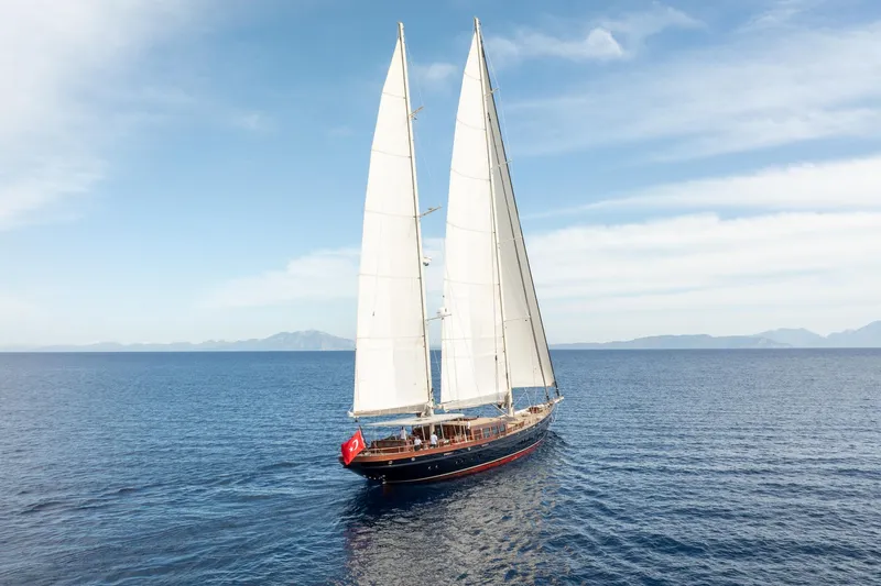Sallyna Yacht Photos Pics 2023 Su Marine sailing yacht with white sails on open sea under clear sky.