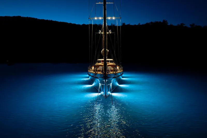 Sallyna Yacht Photos Pics 2023 Su Marine sailing yacht illuminated on water at night.