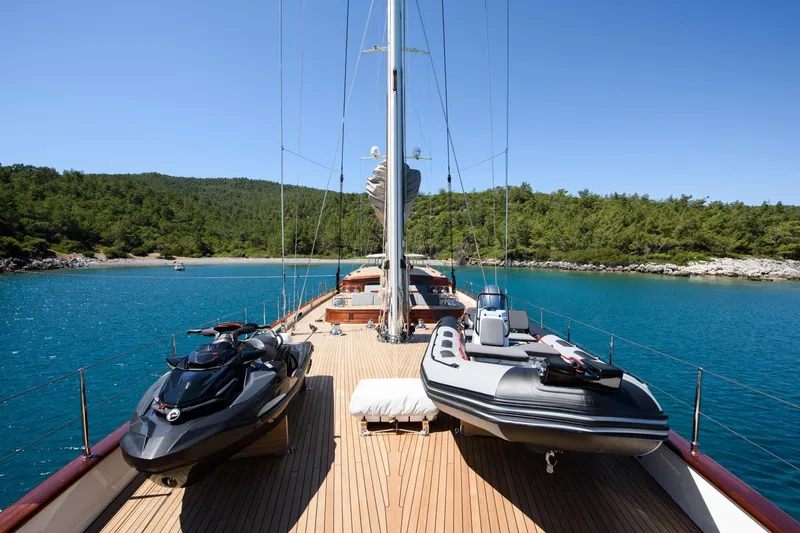 Sallyna Yacht Photos Pics Luxurious 2023 Su Marine sailing yacht deck with jet ski and tender, anchored in serene bay.