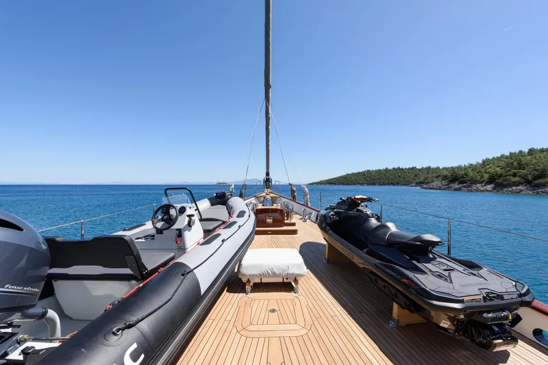 Sallyna Yacht Photos Pics Luxurious 2023 Su Marine sailing yacht deck with jet ski and tender, cruising in clear blue waters.