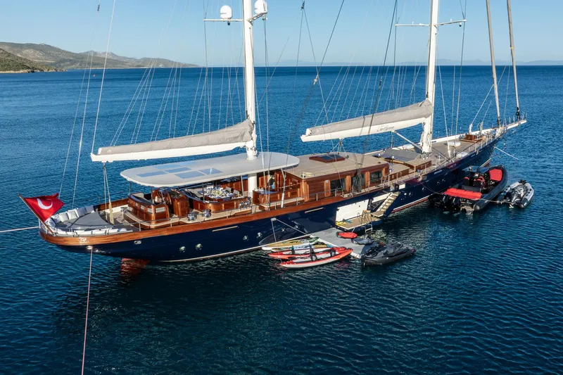 Sallyna Yacht Photos Pics Luxurious 2023 Su Marine sailing yacht anchored with watercrafts, featuring elegant design and spacious deck.