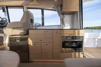 Interior of 2024 Nimbus 365 Coupe featuring modern kitchen and helm seat.