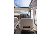 Interior view of 2024 Nimbus 365 Coupe boat with steering wheel and sunroof.