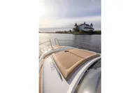 2024 Nimbus 365 Coupe cruising near a historic castle on a serene lake.