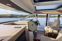 Interior of 2024 Nimbus 365 Coupe yacht with modern helm and panoramic windows.