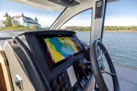 2024 Nimbus 365 Coupe dashboard with navigation system, overlooking scenic waters and historic architecture.