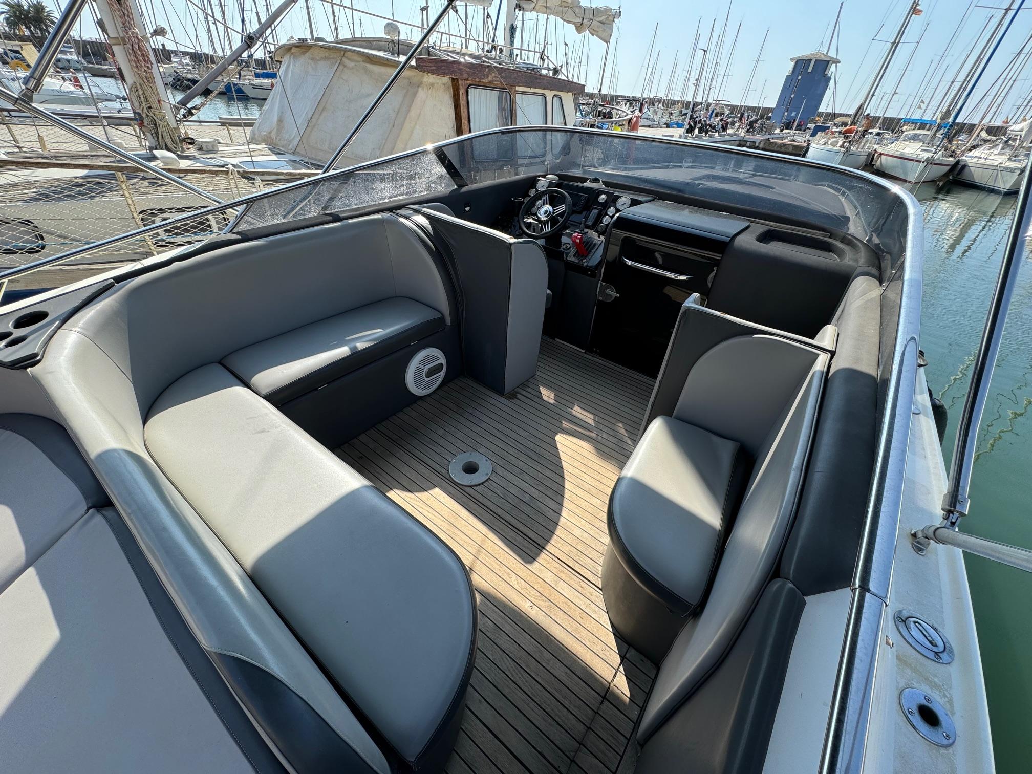 Luxury 1997 Performance 1107 boat interior with sleek seating and wooden deck at marina.