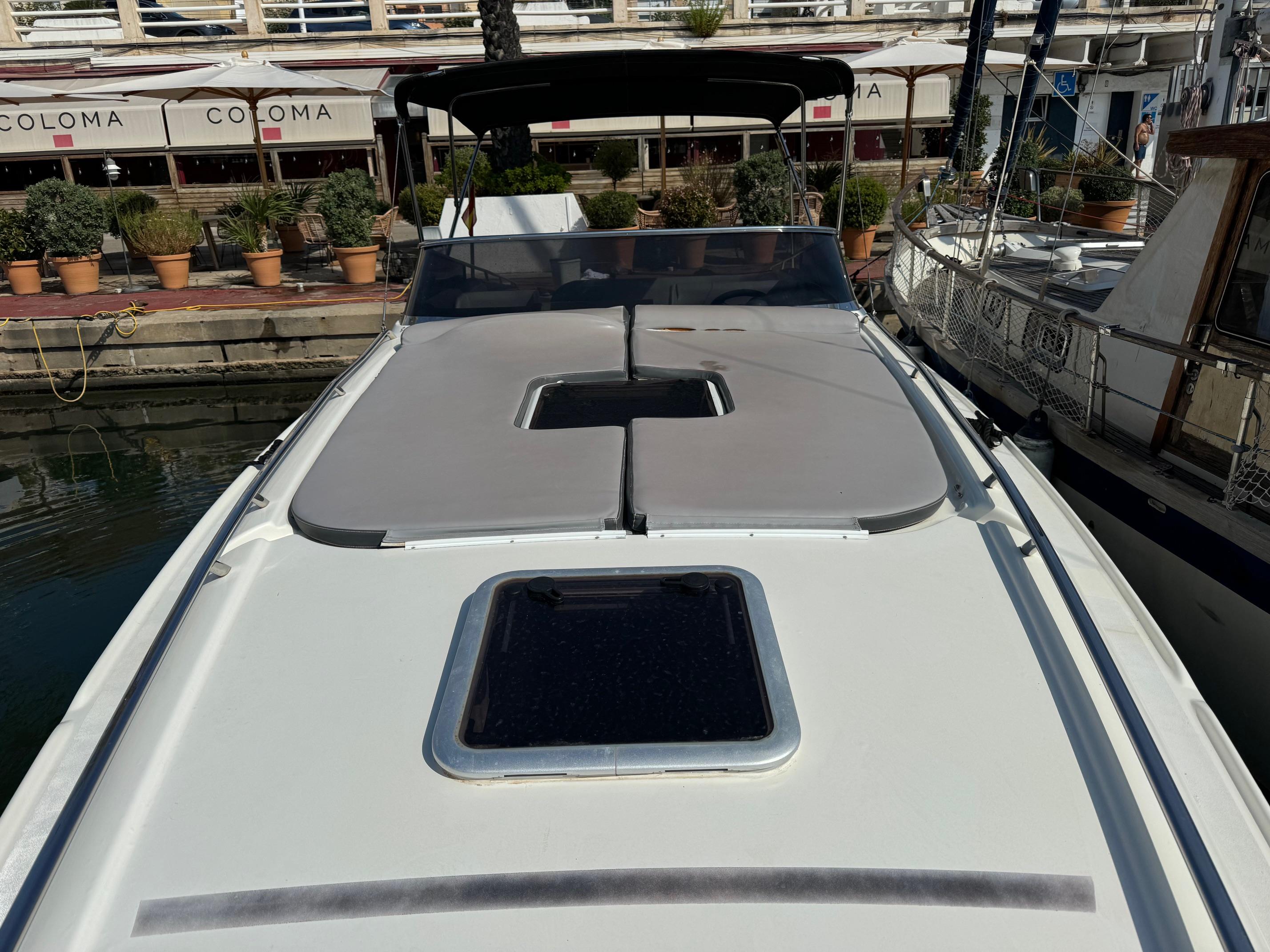 1997 Performance 1107 boat docked, featuring sunbathing area and sleek design.