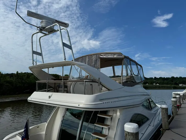 Jjetsdream Yacht Photos Pics 1999 Maxum 4600 SCB yacht docked by a serene river under a clear blue sky.