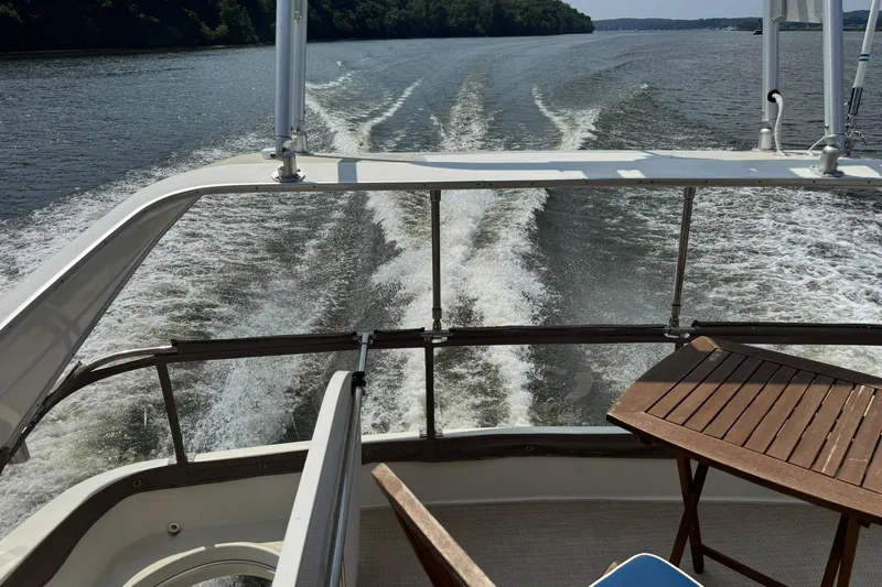 Jjetsdream Yacht Photos Pics 1999 Maxum 4600 SCB yacht cruising on a river, view from deck with table.