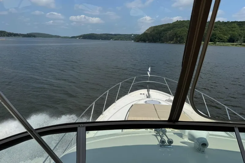 Jjetsdream Yacht Photos Pics 1999 Maxum 4600 SCB yacht cruising on a scenic lake under a clear sky.