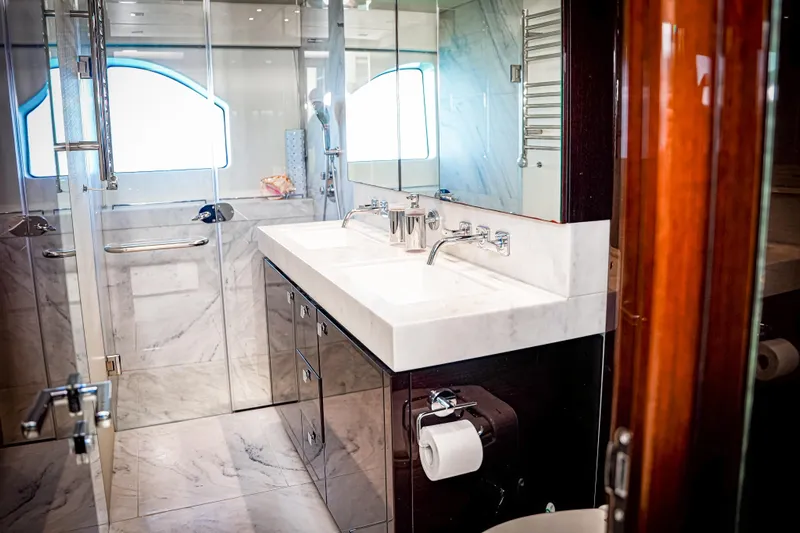 Solaire Yacht Photos Pics Luxurious bathroom interior of 2019 Sunseeker 76 Yacht with marble finishes and modern fixtures.