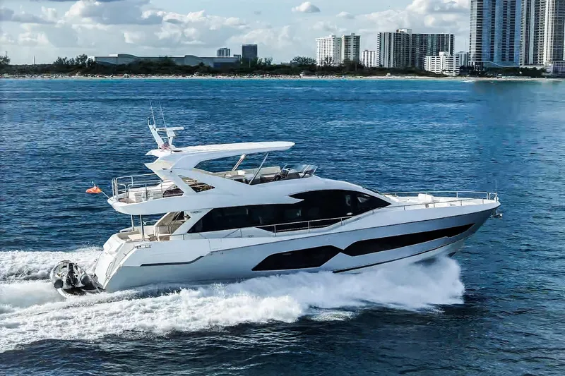 Solaire Yacht Photos Pics 2019 Sunseeker 76 Yacht cruising on blue ocean near city skyline.