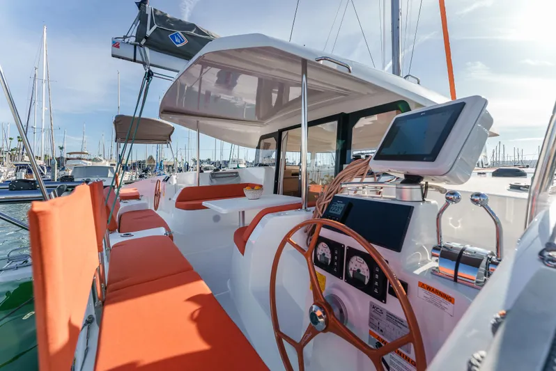 In Stock #169 Yacht Photos Pics 2024 Excess 11 sailboat cockpit with orange seating and modern navigation equipment.