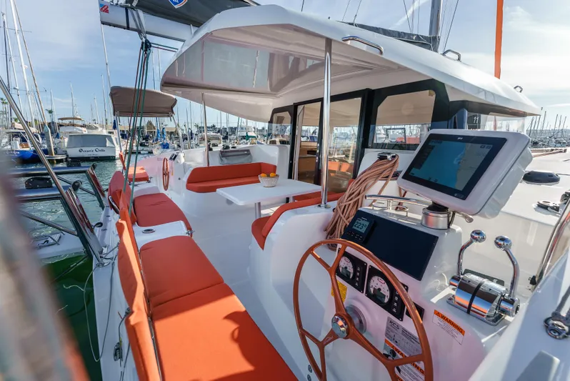 In Stock #169 Yacht Photos Pics 2024 Excess 11 yacht with orange seating, modern helm, and marina backdrop.