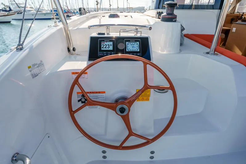 In Stock #169 Yacht Photos Pics 2024 Excess 11 yacht steering wheel and navigation display in marina setting.