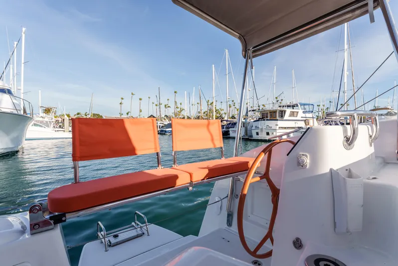 In Stock #169 Yacht Photos Pics 2024 Excess 11 sailboat cockpit with orange seating, docked in a marina.