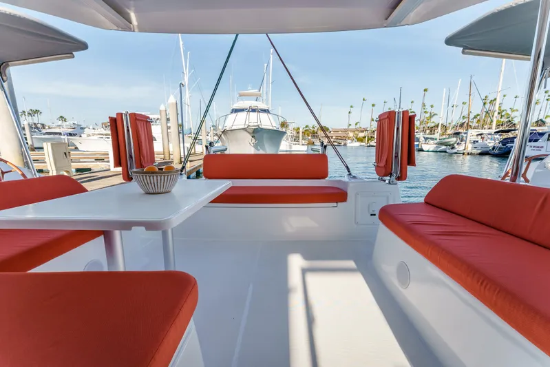 In Stock #169 Yacht Photos Pics 2024 Excess 11 catamaran with orange seating, docked at a marina.