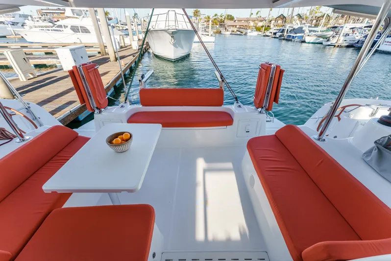 In Stock #169 Yacht Photos Pics 2024 Excess 11 yacht with orange seating, docked in a marina.