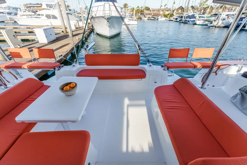 In Stock #169 Yacht Photos Pics Spacious 2024 Excess 11 yacht with orange seating, docked at a marina.