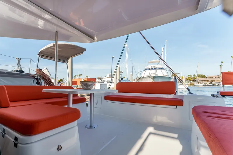 In Stock #169 Yacht Photos Pics 2024 Excess 11 catamaran with red seating in a marina setting.