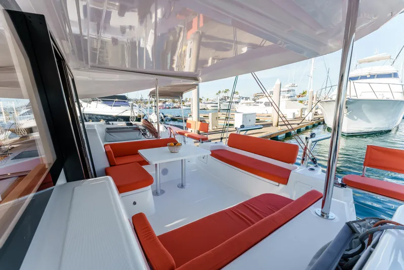 In Stock #169 Yacht Photos Pics Spacious 2024 Excess 11 catamaran with red seating at marina.