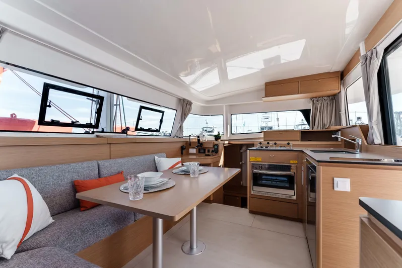 In Stock #169 Yacht Photos Pics Modern interior of 2024 Excess 11 catamaran with dining area and kitchen.
