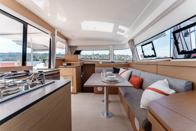 In Stock #169 Yacht Photos Pics Luxurious interior of 2024 Excess 11 catamaran with modern kitchen and cozy seating area.