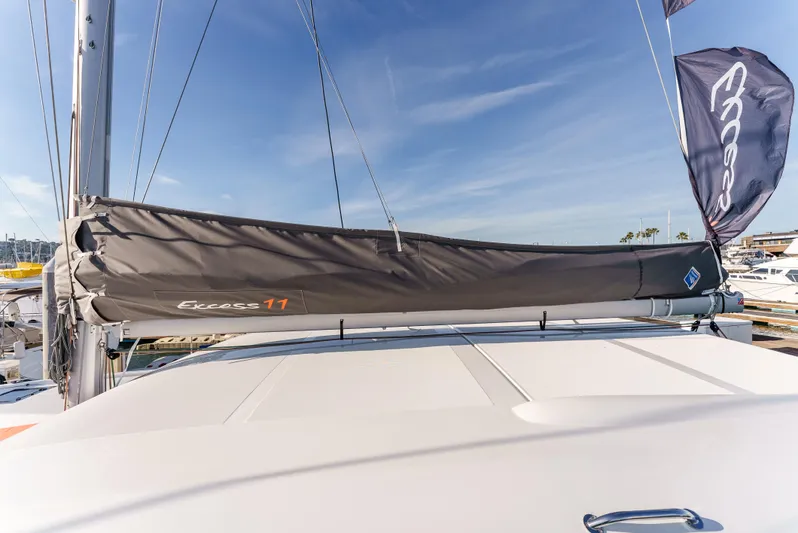 In Stock #169 Yacht Photos Pics 2024 Excess 11 sailboat with covered boom, docked under clear blue sky.