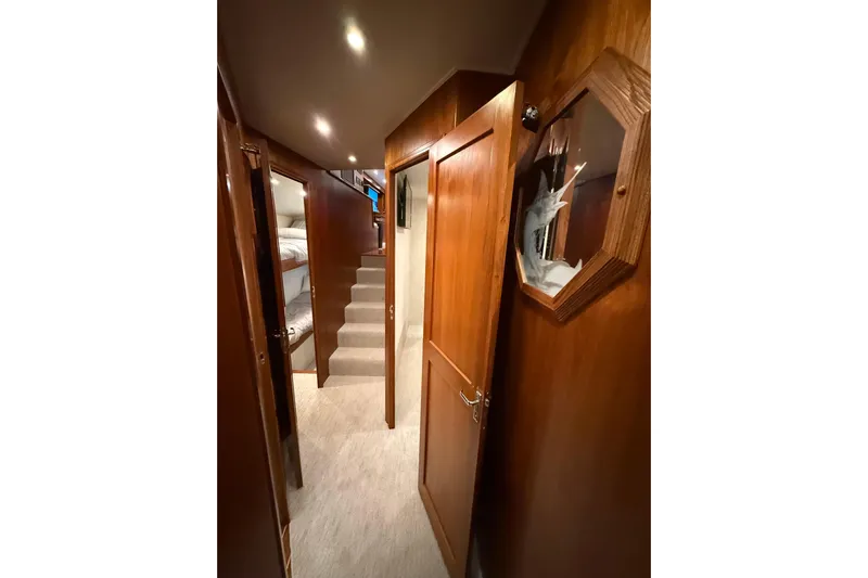  Yacht Photos Pics Interior hallway of 2006 Blackwell 66 Convertible yacht with wooden paneling and carpeted stairs.