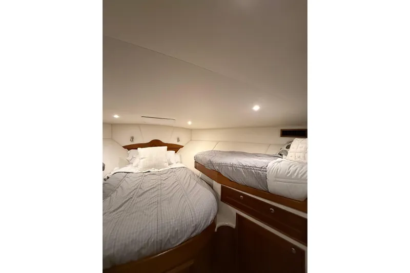  Yacht Photos Pics Interior cabin of 2006 Blackwell 66 Convertible yacht with twin beds and wooden accents.