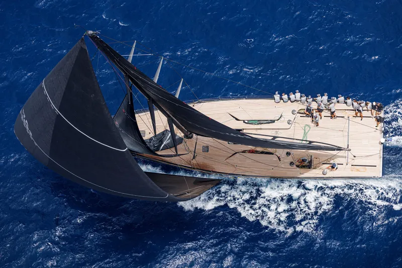 Bullitt Yacht Photos Pics Aerial view of 2018 Wally Custom sailboat navigating vibrant blue ocean waters.