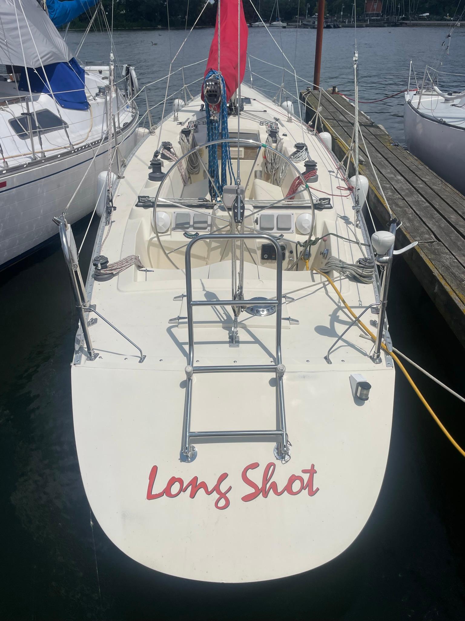 1986 Reliance 12m sailboat named "Long Shot" docked at a marina.
