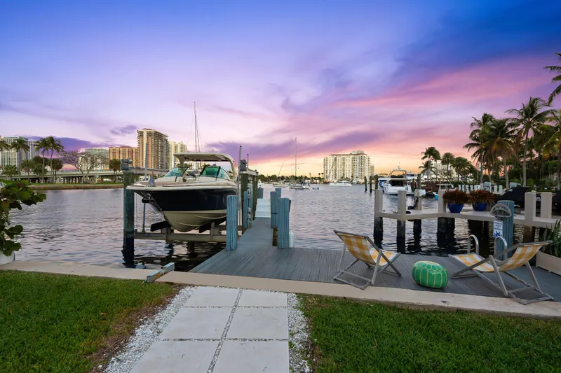  Yacht Photos Pics 2023 Chris-Craft Launch 31 GT docked at sunset, with cityscape and palm trees in the background.