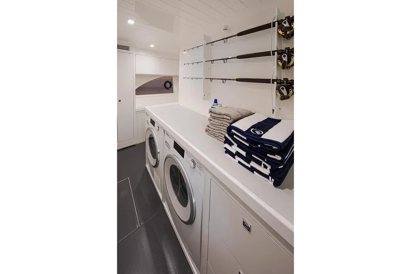  Yacht Photos Pics Manufacturer Provided Image: Laundry room in 2021 Riviera 64 Sports Motor Yacht with washer, dryer, and fishing rods.