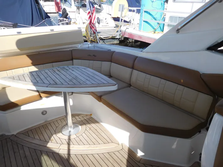  Yacht Photos Pics 2015 Sea Ray 350 SLX boat interior with cushioned seating and wooden table.