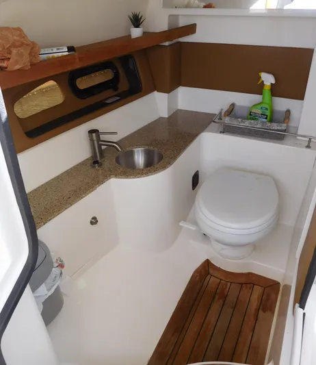  Yacht Photos Pics 2015 Sea Ray 350 SLX boat bathroom with sink, toilet, and wooden floor accents.