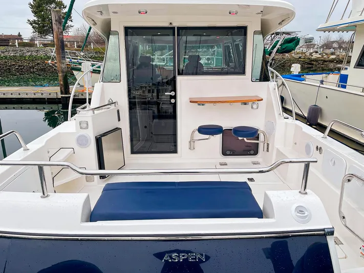 Sojourn Yacht Photos Pics Aspen C108 2022 boat with seating and cabin, docked at marina.