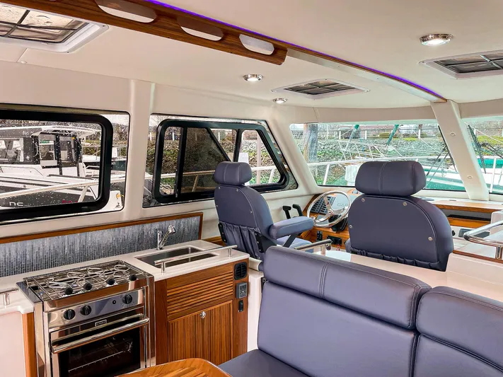 Sojourn Yacht Photos Pics Interior of 2022 Aspen C108 boat with modern seating and kitchen area.