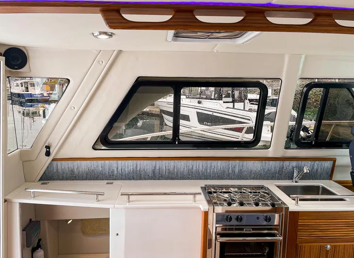 Sojourn Yacht Photos Pics Interior of 2022 Aspen C108 boat with kitchen and window view of marina.