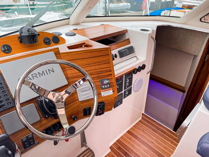 Sojourn Yacht Photos Pics Interior of 2022 Aspen C108 boat with Garmin navigation system and wooden dashboard.