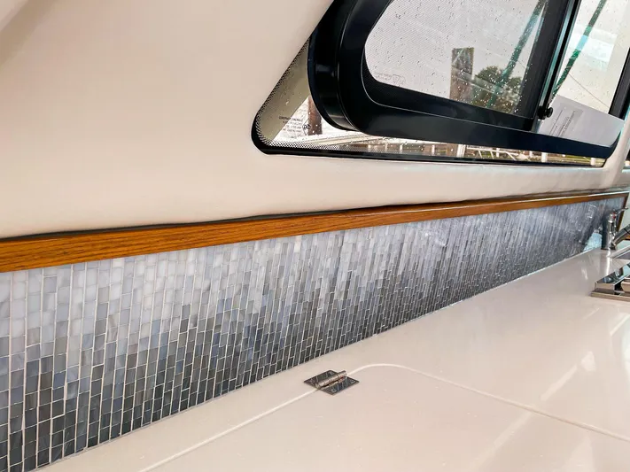 Sojourn Yacht Photos Pics Interior of 2022 Aspen C108 boat with mosaic tile accent and wooden trim.