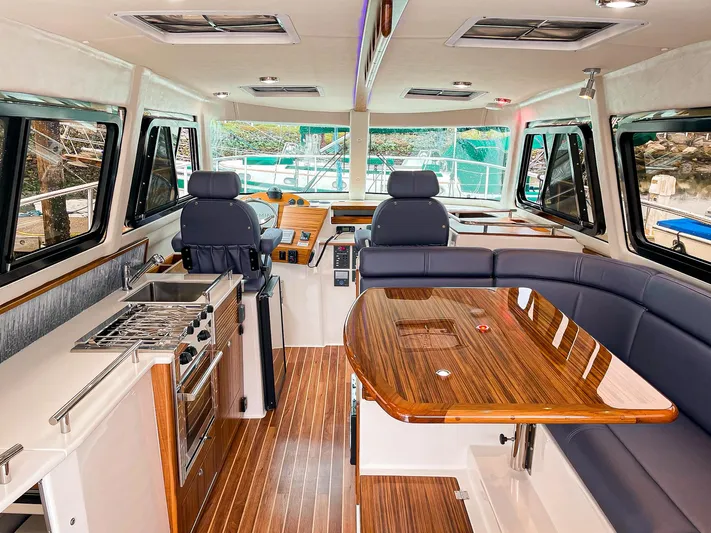Sojourn Yacht Photos Pics Luxurious interior of 2022 Aspen C108 boat with modern kitchen and seating area.